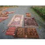 An Eastern design rug, decorated with a patterned central field to a dark red ground, 52ins x 33ins,