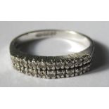 An 18 carat white gold eternity ring, set with two rows of nine single cut diamonds, nineteen in