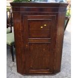 An Antique oak corner cupboard, with mahogany banding to the door, fitted with three shelves,