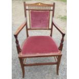 An Edwardian mahogany and satinwood open arm chair, with upholstered panel to the back and seat