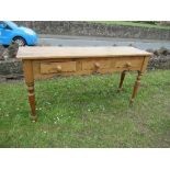 A pine sideboard, having three short drawers above a shaped apron, raised on turned legs, 58ins x