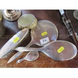 A hallmarked silver dressing table mirror and two brushes, together with another brush, and a