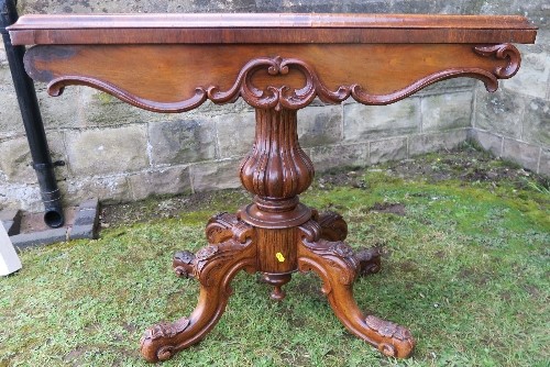 A 19th century fold over games table, raised on a turned and carved column, with four carved - Image 2 of 4