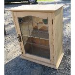 A pine wall cabinet, with stained glass door, opening to reveal shelf, width 20.75ins x height 25ins