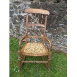 A country style rocking chair, with spindle back and cane seat