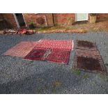 An eastern design rug, decorated with medallions to a central field in a red ground 52ins x 32ins,