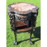 An oriental hardwood jardinière stand, the shaped and carved top inset with marble, having carved