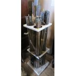 A collection of brass stair rods, of various designs, in a stand