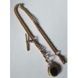 A 9 carat gold watch chain, of uniform solid curb inks, with a T bar, swivel catch and a seal fob,