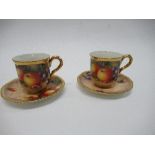 Two Royal Worcester coffee cans and saucers, decorated all around with hand painted fruit by Freeman