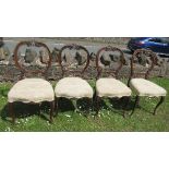 A set of four 19th century balloon back dining chairs, with pierced and carved top crest and rail,