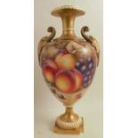 A Royal Worcester vase, raised on a pedestal, decorated half round with hand painted fruit by