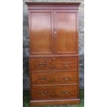 A mahogany cabinet on chest, of drawers, the upper section having a pair of cupboard doors opening