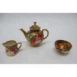 A Royal Worcester miniature tea pot, milk jug and sugar bowl, all decorated with hand painted