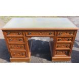 An Edwardian oak desk, with tooled leather writing surface to the top and fitted with an arrangement