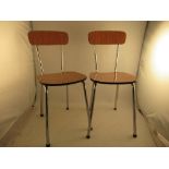A pair of chrome and wood-effect chairs, with bar back, and seat raised on tubular legs, from second