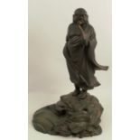 A cast bronze figure, of a Chinese deity standing on a rock by water, height 16ins