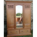 An Edwardian walnut mirror door wardrobe, with carved panels, fitted with two doors either side of a