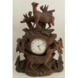 A 19th century oak Black Forest mantel clock, carved with deer and foliage, the dial marked 8 Days
