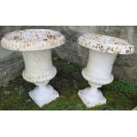 A pair of painted metal campagna shaped garden urns, raised on square bases, height 17ins