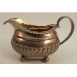 A Georgian silver jug, with gadrooned lower body and leaf moulded handle, London 1825, weight 6oz