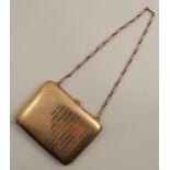 A yellow metal lady's coin purse, with engine turned decoration, marked 12KT, with chain handle,