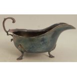 A silver sauce boat, with shaped edge, scroll handle and raised on three scroll legs, Chester