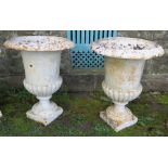 A pair of painted metal campagna shaped garden urns, raised on square bases, height 19ins