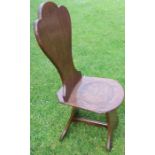 A late Georgian oak hall chair with trefoil shaped back and dished seat, and having a trestle
