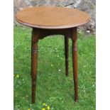 A 19th century Arts and Crafts oak lamp table, with circular top and arched sides, standing on splay