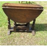 A small oval reproduction oak gate leg coffee table, maximum diameter 20.5ins x height 18.5ins