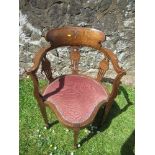 An Edwardian mahogany corner chair, with inlaid curved back, (central inlay missing), to a deep