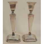 A pair of silver table candlesticks, having square tapering columns to square bases, Birmingham