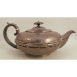 A Georgian silver teapot, of squat circular form , with engraved decoration to the upper body,