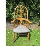 A Windsor armchair, with ornate pierced splat flanked by spindles, with upholstered seat, and raised