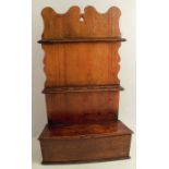 An early 19th century oak spoon rack, the broadly shield shaped back with two banks of six spoon