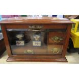 An Edwardian oak stationary cabinet, with rising lid and hinged glazed front opening top reveal