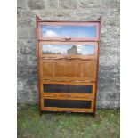 A Globe Wernicke style section book case, having three glazed doors, with a central secretaire