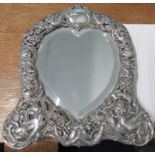 A silver mounted dressing table mirror, the plate of heart shape, the silver mount with pierced