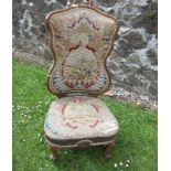 A 19th century walnut framed nursing chair, having ornate shield shaped back, with distressed