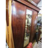 A 19th century mahogany compactum, having central mirror door, flanked by two doors , opening to