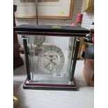 A modern mantel clock, with silver dial and skeleton movement, behind four glass panels, height