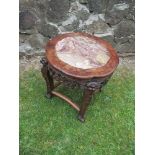 An Eastern style occasional table, having marble inlaid top, carved frieze and legs, united by