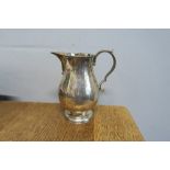 A silver jug, of baluster form, raised on a circular foot, London 1929, weight 8oz