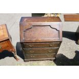 A 20th century oak bureau, with moulded decoration to the drop flap, over three long drawers,