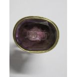A 19th century seal fob, set with a monogrammed foil back purple stone - Some wear and thin areas on