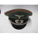 A Third Reich style visor cap, in green felt with red piping with a dark green hat band, silver