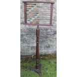 An Antique abacus, with coloured wooden beads, on a turned column, with metal base, height 58ins