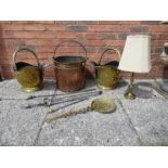 Two brass helmet shaped coal scuttles, a candlestick lamp, copper log bin, irons, etc.