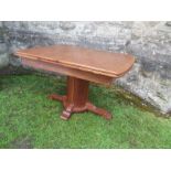 An oak extending dining table, raised on a central cylindrical column, in the Art Deco style, having